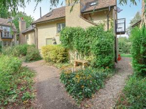a house with a bench in front of a garden at Riverview in Somerford Keynes