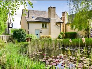 a house with a lily pond in front of it at Riverview in Somerford Keynes