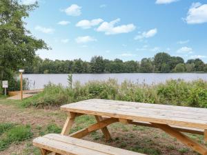 a wooden picnic table in front of a lake at Riverview in Somerford Keynes +24 photos