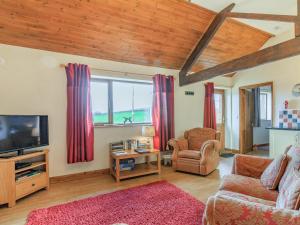 a living room with a couch and a tv at The Cartlinhay - Uk35756 in Bideford