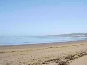 an empty beach with the ocean in the background at Ysgubor Wen in Burry Port
