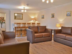 a living room with two chairs and a couch at Ysgubor Wen in Burry Port