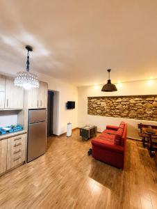 a living room with a red couch and a kitchen at Olive Coast House 3 100m from the sea in Kyparissia