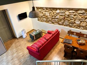 a living room with a red couch and a table at Olive Coast House 3 100m from the sea in Kyparissia
