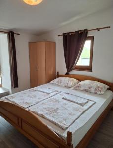 a bedroom with a large bed with a window at Pansion & Apartments MOST Blagaj in Blagaj