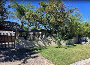 a yard with a fence and a tree at Anja Guesthouse in Modimolle
