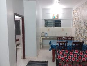 a kitchen with a table and chairs in a room at Blue Pearl Cottage in Ooty