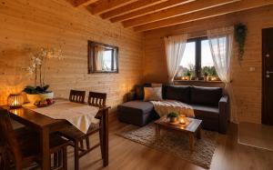 a living room with a couch and a table at Bursztynowe Domki in Sarbinowo