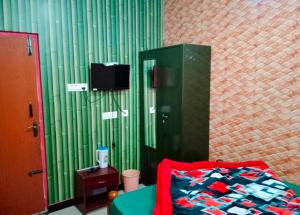 a bedroom with a bed and a green wall at Blue Pearl Cottage in Ooty