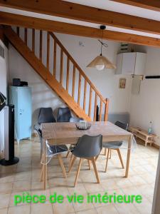 a dining room with a wooden table and chairs at Maison de vacances Hameau de la Grande baie À 200m de la plage ! in Dolus-d'Oléron