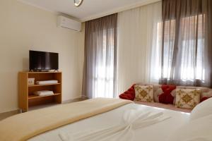 a hotel room with a large bed and a couch at Martin Villa 2 in Gjirokastër