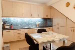 a kitchen with a table with chairs and a sink at Martin Villa 2 in Gjirokastër