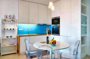 a kitchen with white cabinets and a table and chairs at Seafront Villa Moments, by Estia in Mochlos +27 photos