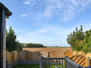 a wooden fence with a field in the background at Atmospheric in Patrington