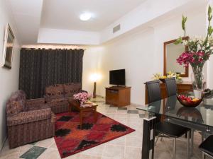 a living room with a couch and a table at Safeer Hotel Suites in Muscat