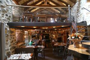 a restaurant with tables and chairs in a room at La Ferme du bien-être in Saint-Julien-Chapteuil