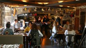 a group of people sitting at tables in a restaurant at La Ferme du bien-être in Saint-Julien-Chapteuil