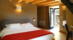 a bedroom with a large bed with a red blanket at La Ferme du bien-être in Saint-Julien-Chapteuil