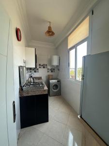 a small kitchen with a sink and a refrigerator at Surf and Tribe in Tamraght Ouzdar +26 photos