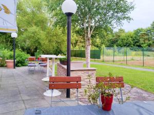 a patio with benches and a table and a lamp at Braunschweig Seminarius Hotel by Belvilla in Braunschweig