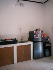 a kitchen with a stainless steel refrigerator and a sink at beaches Lyfe Rooms in Kuta Lombok
