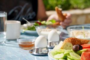 a table with a plate of food with fruit and eggs at Domizil Lina Art in Güzelçamlı