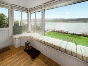 a large window seat in a room with a view of the water at Failte in Colintraive