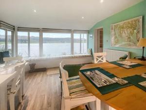 a dining room with a table and a view of the water at Failte in Colintraive