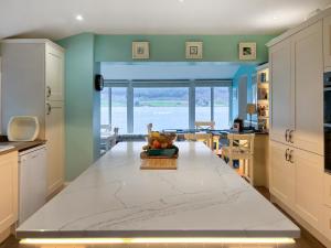 a kitchen with a table with a bowl of fruit on it at Failte in Colintraive +23 photos