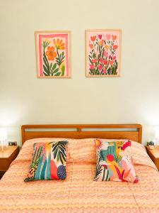 a bed with two pillows and two pictures on the wall at Terrazza sul Borgo in Camerota