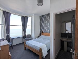 a bedroom with a bed and a sink and windows at Areawest in Scarborough