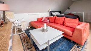 a living room with a red couch and a table at Seawiew in Helsingborg