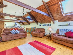 a living room with leather furniture and wooden ceilings at The Threshing Barn - Uk35754 in Bideford