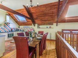 a kitchen and dining room with a wooden table and chairs at The Threshing Barn - Uk35754 in Bideford
