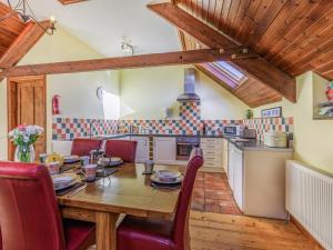 a kitchen and dining room with a wooden table and chairs at The Threshing Barn - Uk35754 in Bideford +16 photos
