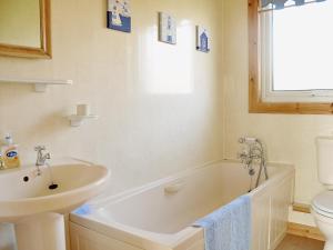 a bathroom with a sink and a tub and a toilet at Hawthorne in Woolfardisworthy +3 photos