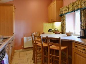 a kitchen with a table and some chairs in it at The Old Stables in Uldale