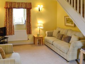 a living room with a couch and a window at The Old Stables in Uldale