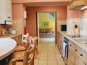 a kitchen with orange walls and a counter top at The Old Stables in Uldale +15 photos