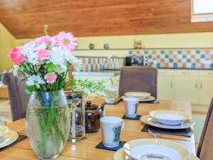 a vase filled with pink and white flowers on a table at The Granary - Uk35755 in Bideford