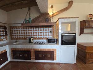 a kitchen with a stove and a microwave at Villa Timea Piscina e Tennis Vista Isole Egadi in Marsala