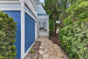 a house with a blue wall and a walkway at SEA2SKY Ocean front private pool and spa in Kure Beach