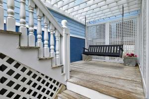a porch with a bench on a house at SEA2SKY Ocean front private pool and spa in Kure Beach +99 photos