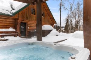 a hot tub in the snow in front of a cabin at Private Pool - Spa - Pool Table - Le St-Come in Saint Come