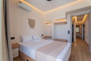 a bedroom with a large white bed and a hallway at SithoniaRS Boho Edition Luxury Roofgarden II in Neos Marmaras