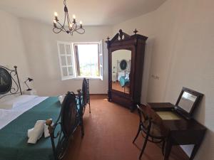 a bedroom with a bed and a table and a mirror at Villa Timea Piscina e Tennis Vista Isole Egadi in Marsala