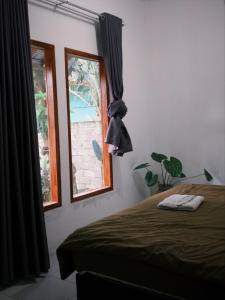 a bedroom with a bed and a window at beaches Lyfe Rooms in Kuta Lombok