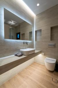 a bathroom with a sink and a toilet and a mirror at SithoniaRS Boho Edition Luxury Roofgarden II in Neos Marmaras