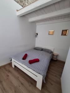 a bedroom with a bed with two red pillows on it at Tre sorelle in Piran