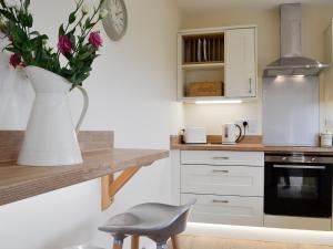 a kitchen with a vase of flowers on a counter at Sweet Meadow Lodge in Llandrindod Wells